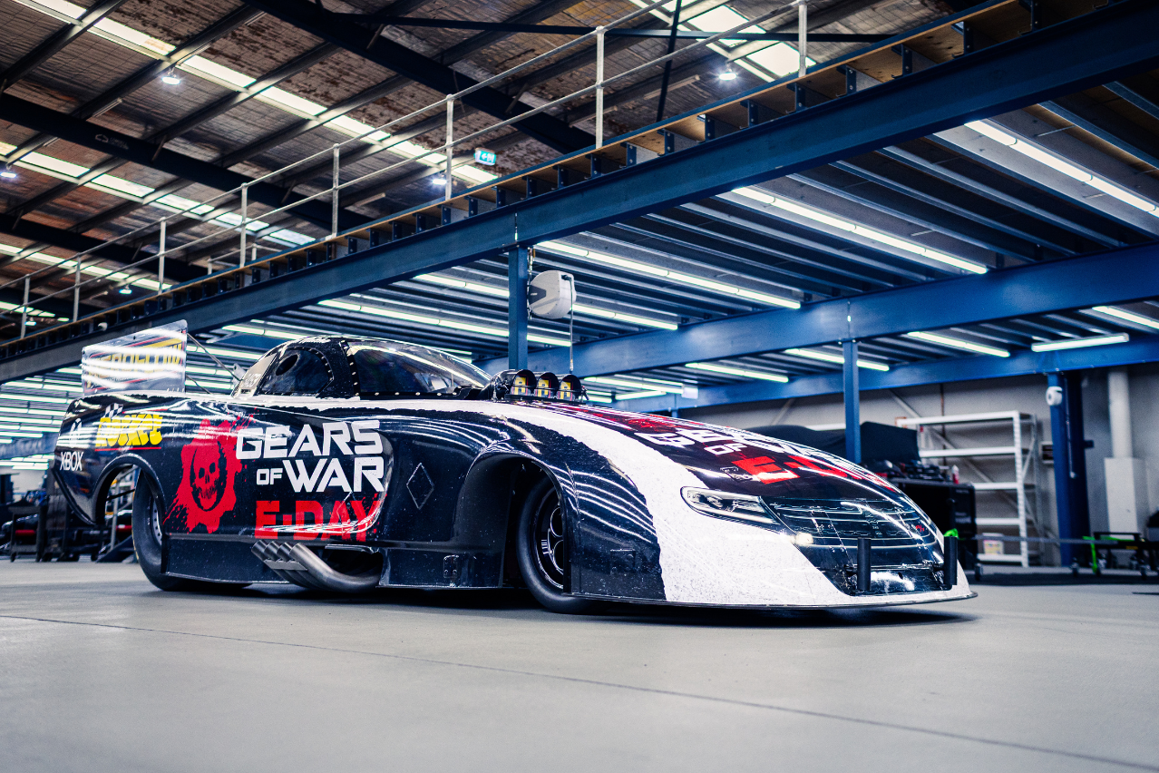 Low three-quarter view of the Xbox Gears of War: E-Day Nitro Funny Car showcasing its full black, white and red livery.