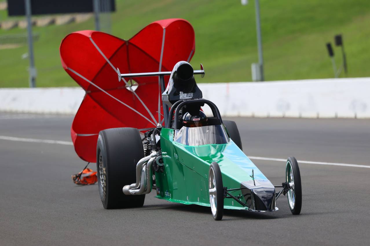 Brooke Rapisarda’s green Modified dragster with its red parachute deployed after a run.