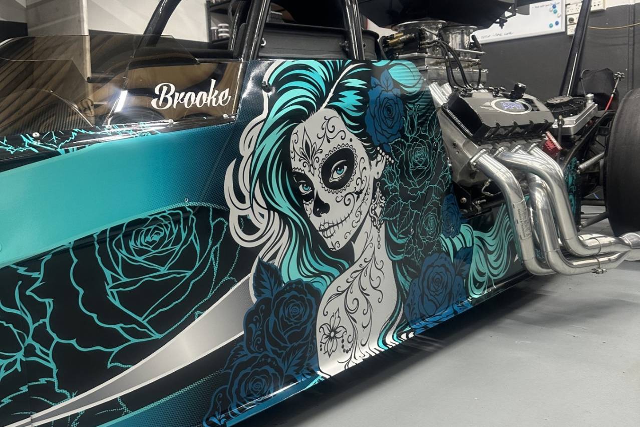 Close-up of Brooke Rapisarda’s Modified dragster showing its black and aqua sugar-skull livery.