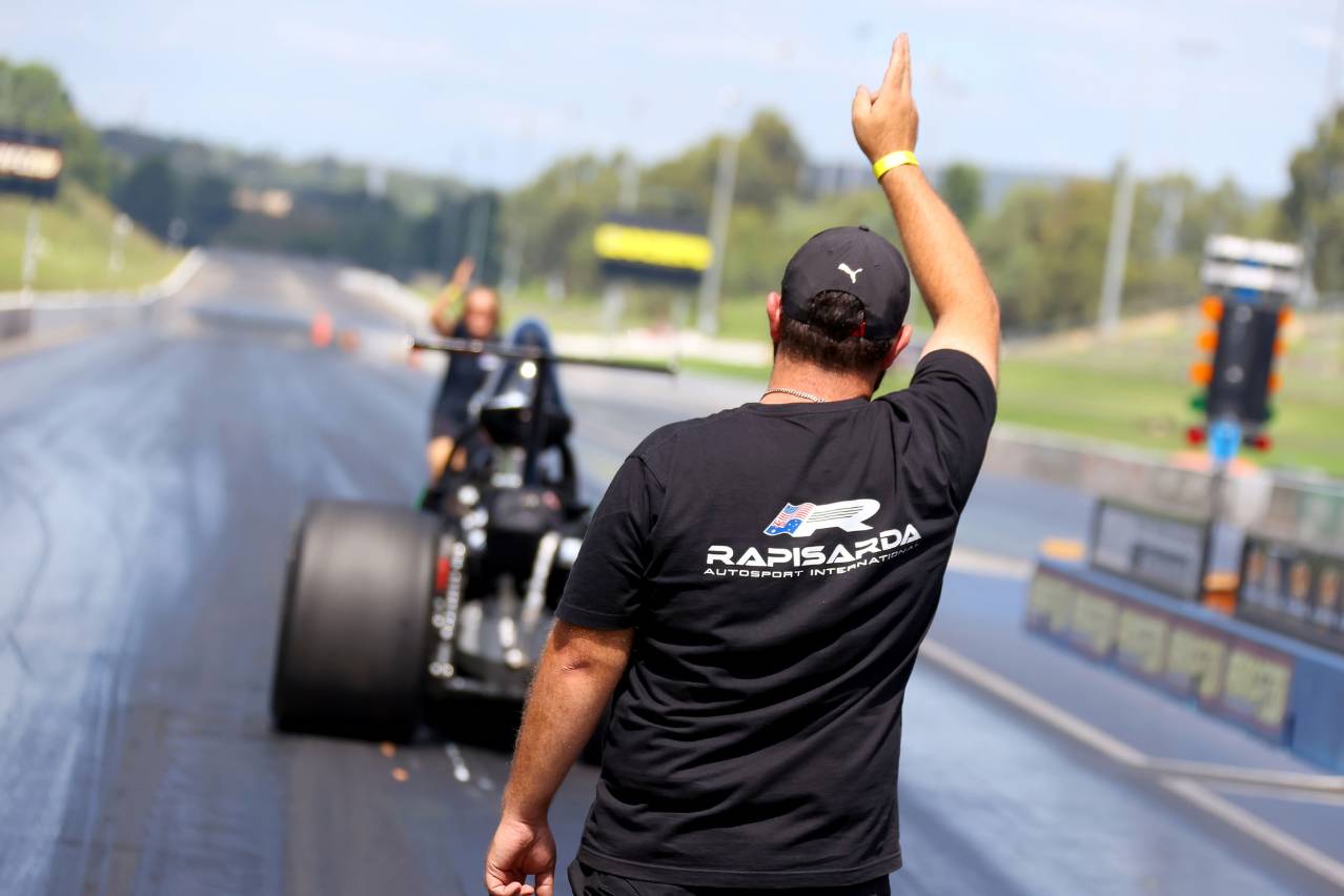 Crew member signals ahead of Brooke Rapisarda’s Modified dragster on the Sydney Dragway track.